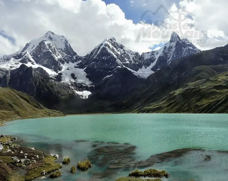 Laguna Carhuacocha en el día 3 del trek largo Huayhuash 8 días 7 noches, con vistas al paso Carnicero y nevados como Siula, Jural y Trapecio