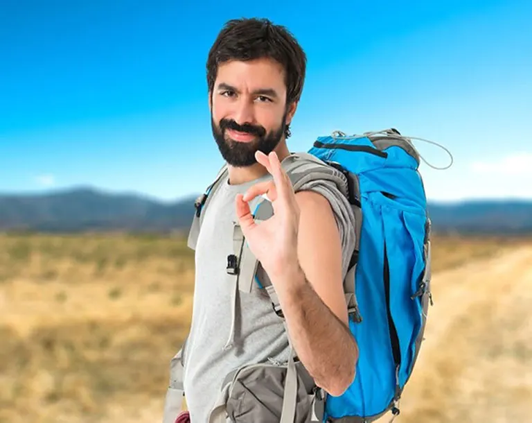 Turista equipado para el tour a Chavín de Huántar con chaqueta ligera, gorra, lentes de sol y mochila pequeña