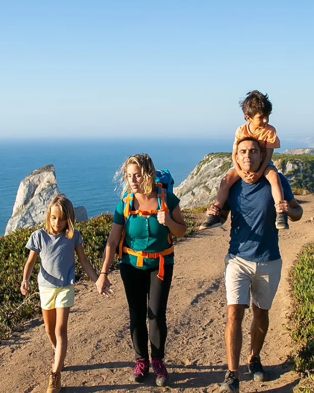 Turista con chaqueta ligera, sombrero, lentes de sol y mochila pequeña en el mirador de Punta Olímpica camino a Chacas